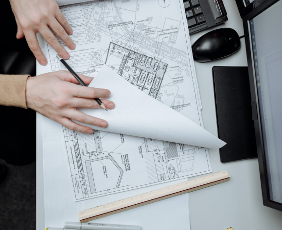 A person reviewing architectural drawings